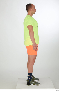 Joel a-pose dressed green sneakers orange shorts sports standing whole…